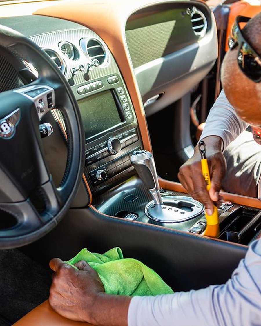George cleaning a Bentley's center console