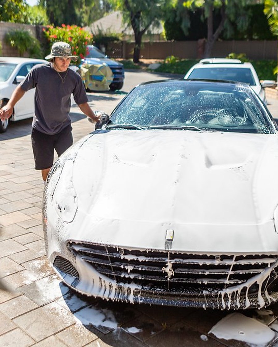 George foam washing a white sports car